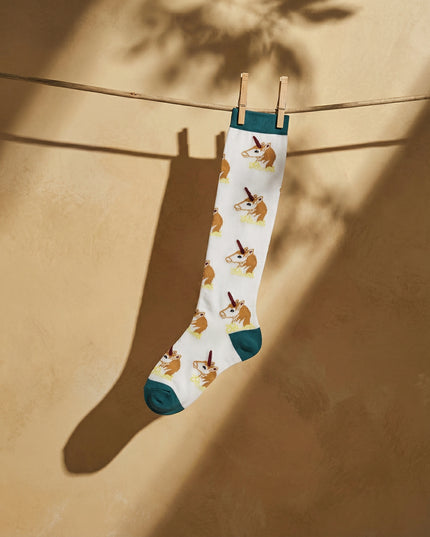 Socks with corgi pattern hanging on a line against a beige wall