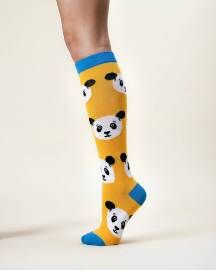 Yellow socks with panda design worn by a person on a white background