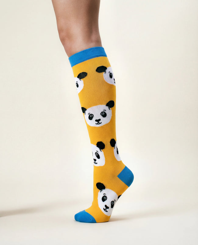 Yellow socks with panda design worn by a person on a white background