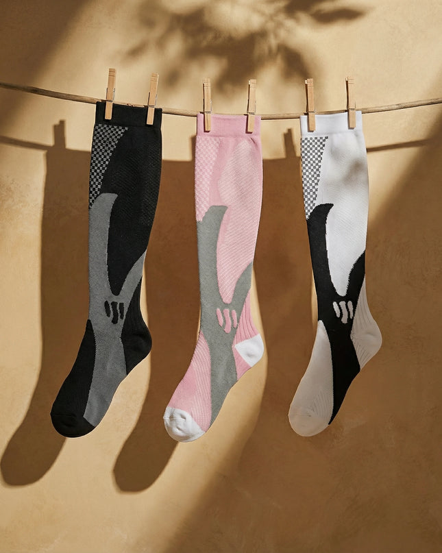 Three pairs of socks hanging on a line against a beige background