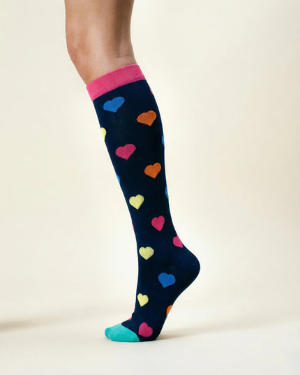 Navy sock with colorful heart patterns worn by a person on a beige background