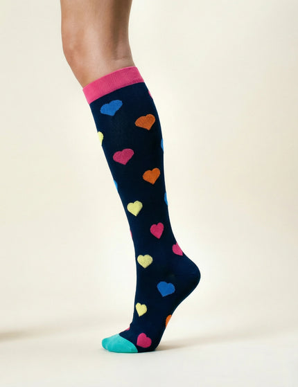 Navy sock with colorful heart patterns worn by a person on a beige background