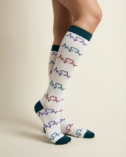 White socks with colorful heart and line pattern worn by a person on a beige background