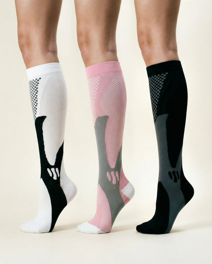 Three pairs of compression socks in white, pink, and black on a neutral background