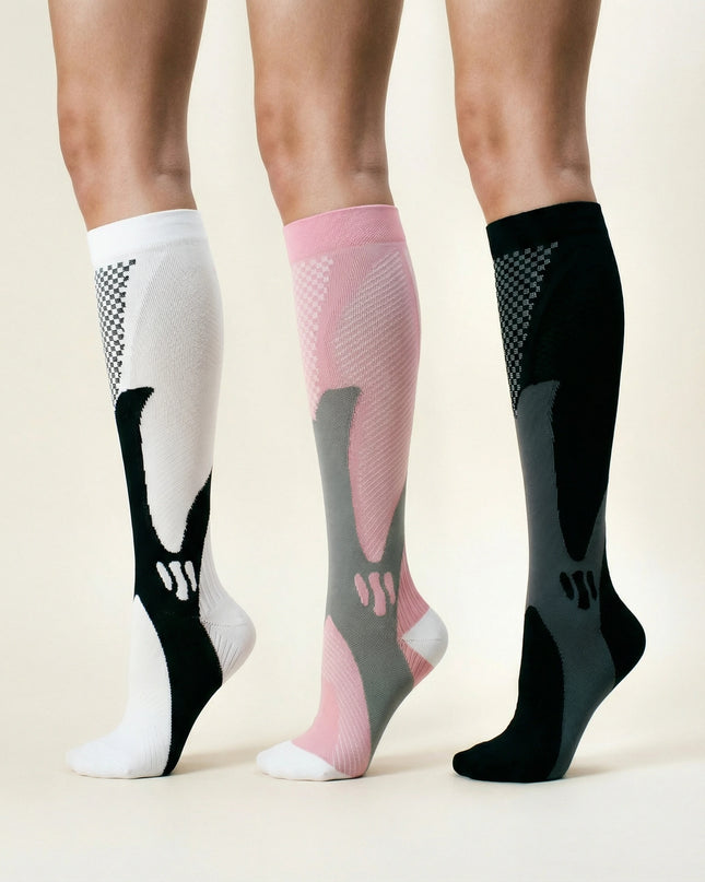 Three pairs of compression socks in white, pink, and black on a neutral background