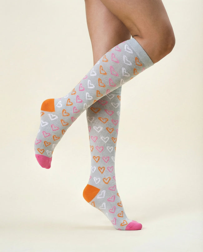 Knee-high socks with heart pattern worn by a person on a beige background