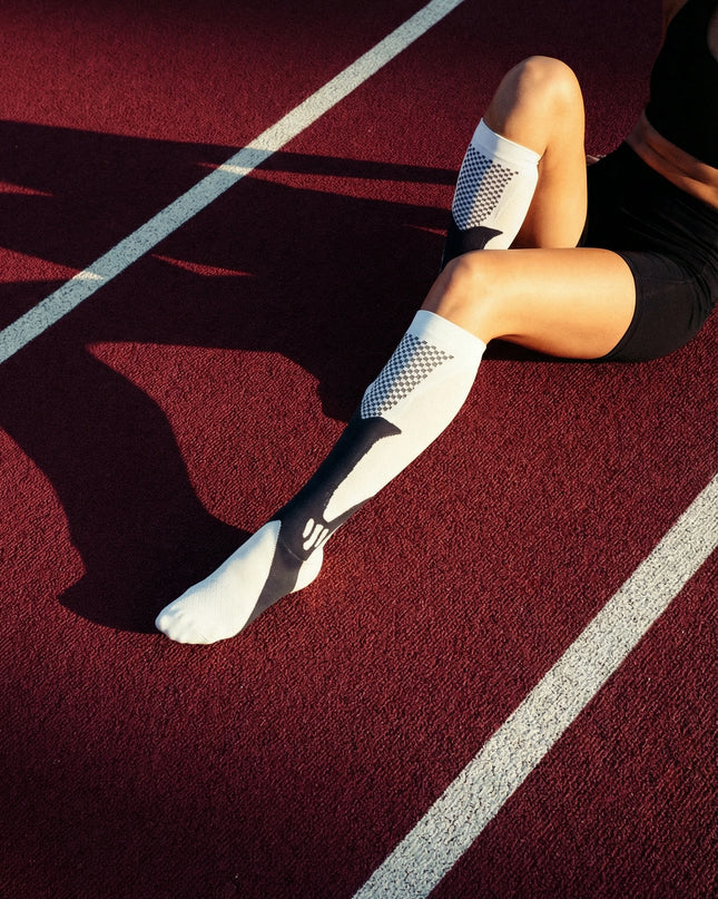 Person wearing white athletic socks on a track