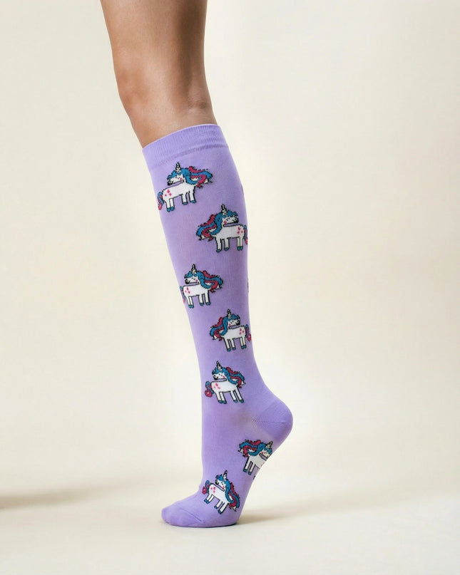 Purple socks with unicorn pattern worn by a person on a light beige background