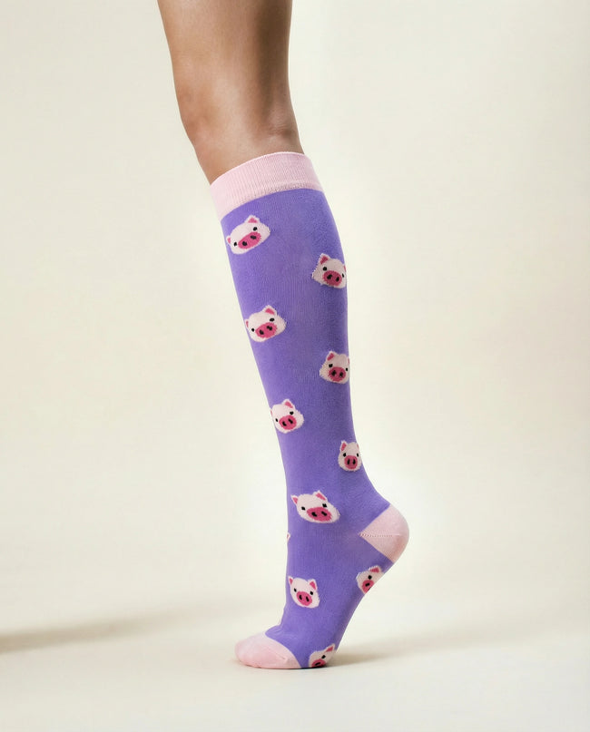 Purple knee-high socks with bear pattern worn by a person on a light background