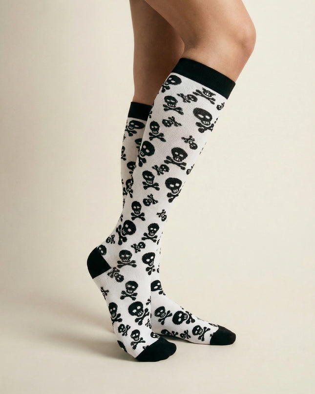 Knee-high socks with skull pattern worn by a person on a beige background