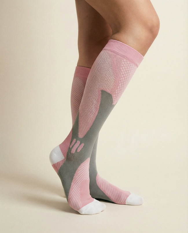Pink and gray compression socks on a beige background