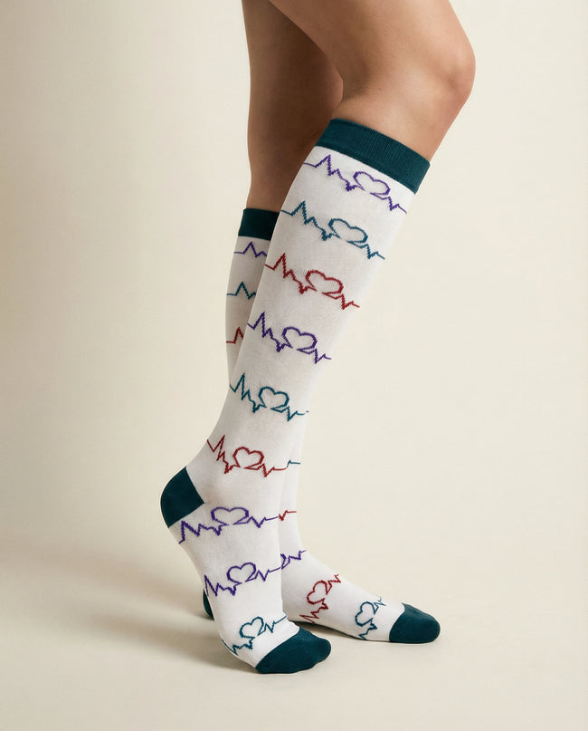 White socks with colorful heart and line pattern worn by a person on a beige background