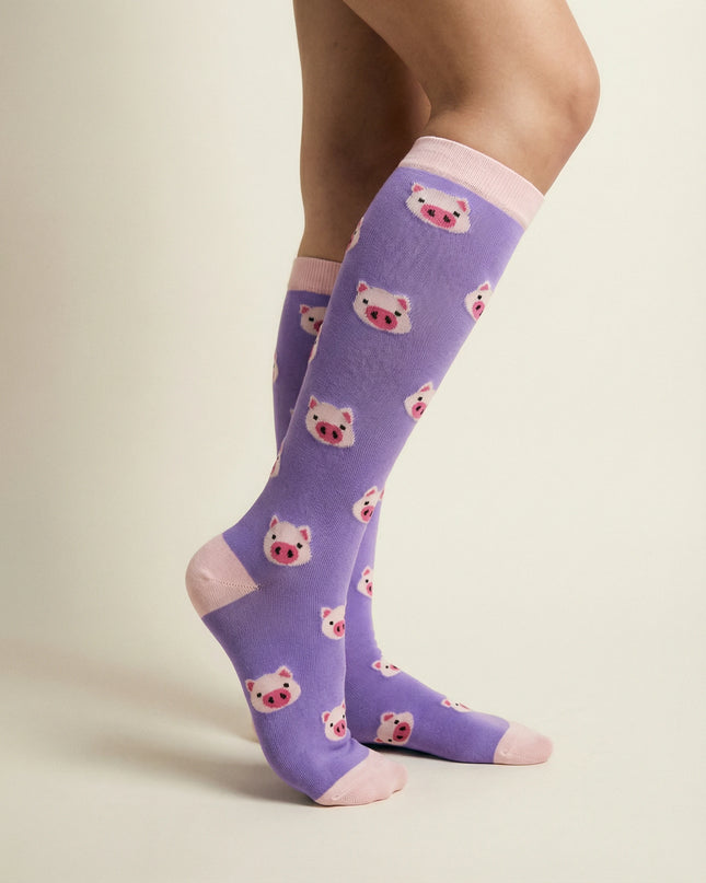Purple socks with bear pattern worn by a person on a beige background