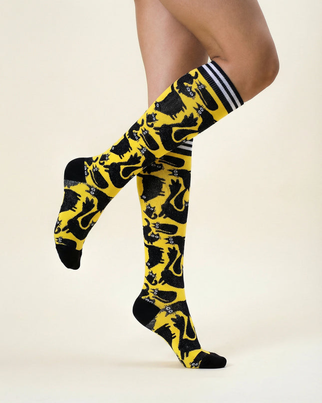 Yellow and black patterned knee-high socks with white stripes on a beige background
