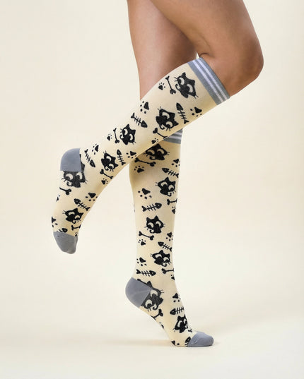 Knee-high socks with black cat pattern on a beige background