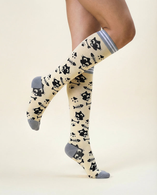 Knee-high socks with black cat pattern on a beige background