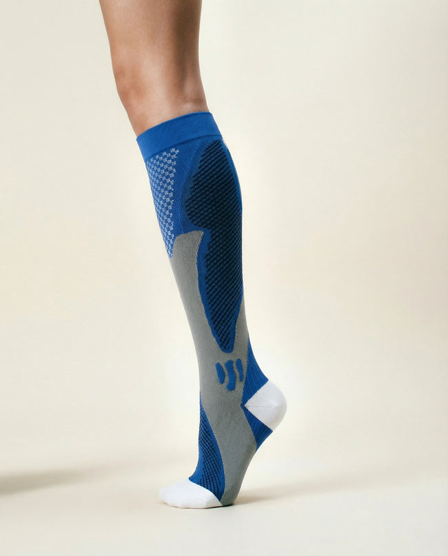 Gray and blue athletic sock on a person's foot against a beige background