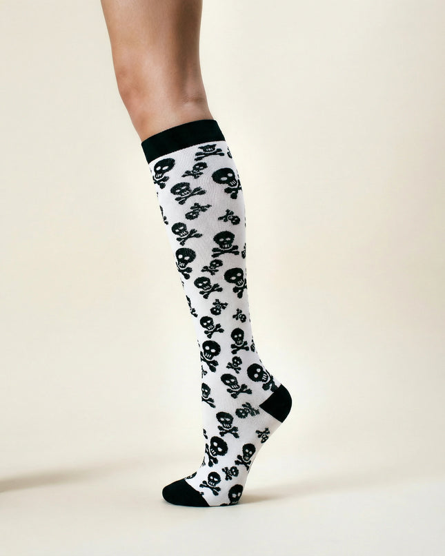 Knee-high socks with skull and crossbones pattern on a beige background