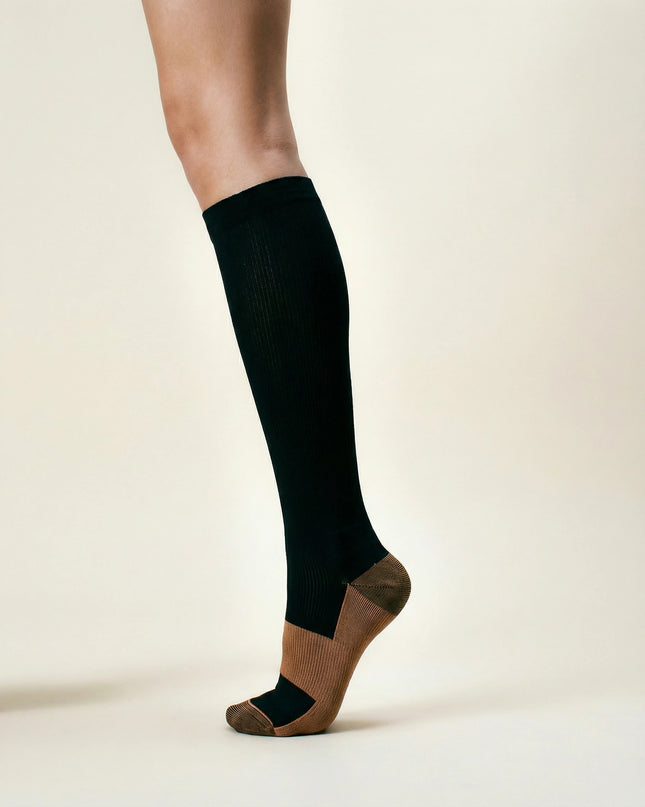 Black knee-high sock worn by a person on a beige background