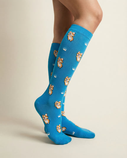 Blue knee-high socks with teddy bear pattern worn by a person on a beige background