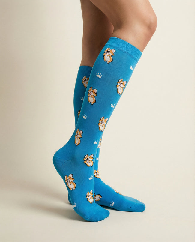 Blue knee-high socks with teddy bear pattern worn by a person on a beige background