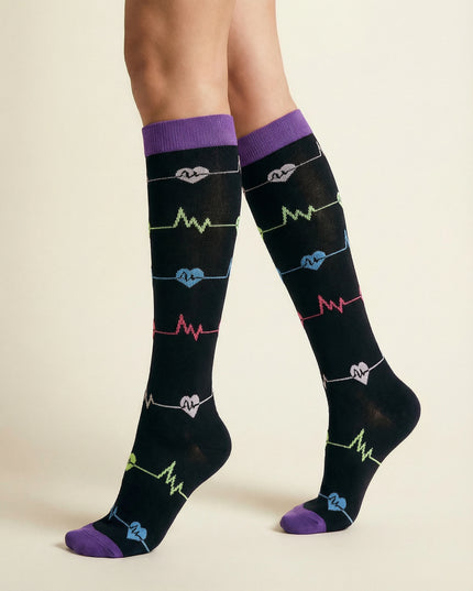 Black knee-high socks with colorful heart and heartbeat line designs on a beige background