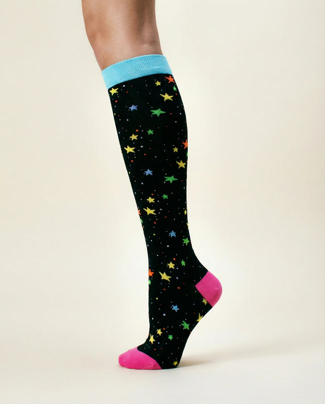 Knee-high sock with colorful star pattern on a plain background