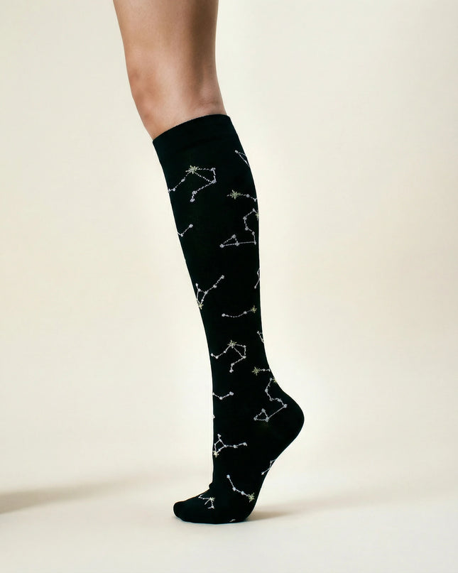 Black knee-high socks with white constellation patterns on a neutral background