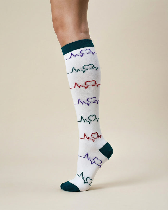 White knee-high sock with colorful heart and line pattern on a beige background