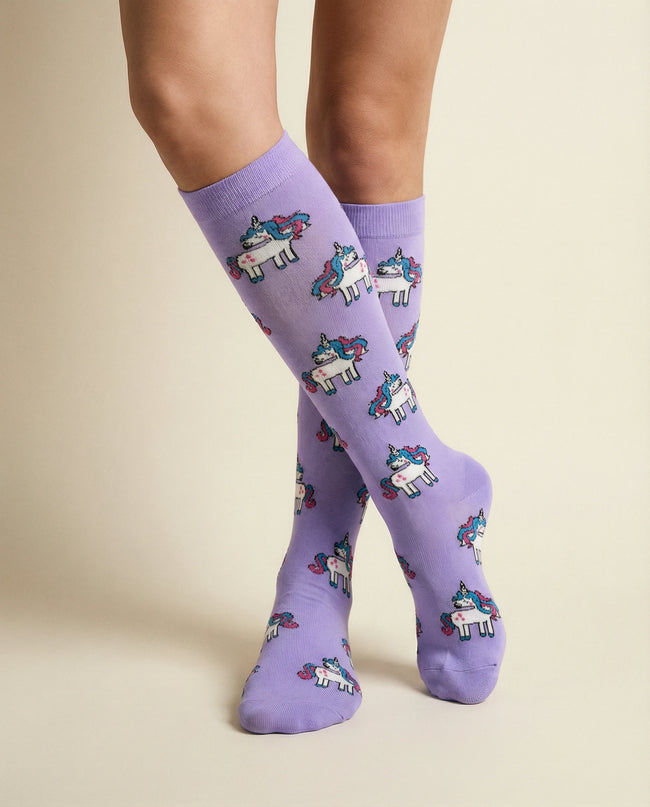 Purple socks with unicorn pattern worn by a person on a beige background