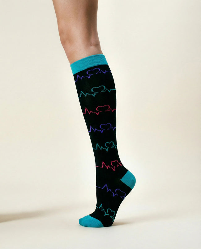Black knee-high sock with colorful heart and wave pattern on a white background
